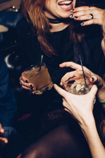two women talking while holding drinking glasses